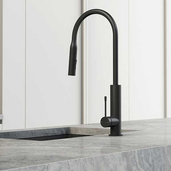 Phoenix Deja matte black pull-out sink mixer with arched swivel spout on a kitchen benchtop, side view
