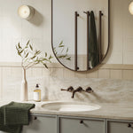 Phoenix vertical rail hook in brushed bronze fitted to a round towel rail in a bathroom mirror view