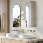 Brushed nickel wall basin mixer set with twin round handles above a double vanity in a modern bathroom.