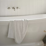 Phoenix Nostalgia brushed nickel wall basin/bath set with lever handles above a white freestanding bath