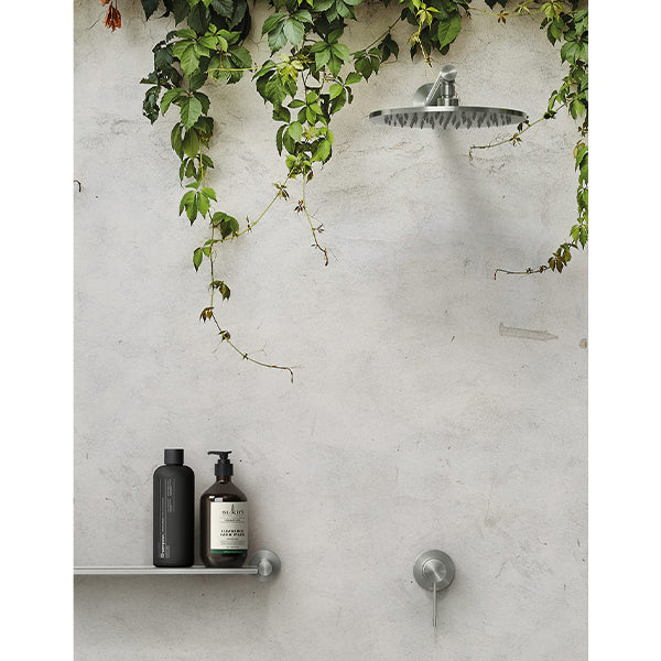Phoenix Vivid Slimline stainless steel wall mixer and shower head in an outdoor shower setting, with slim lever and round wall plate