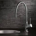 Phoenix Vivid Slimline chrome gooseneck sink mixer with oval base, shown mounted beside a round sink basin