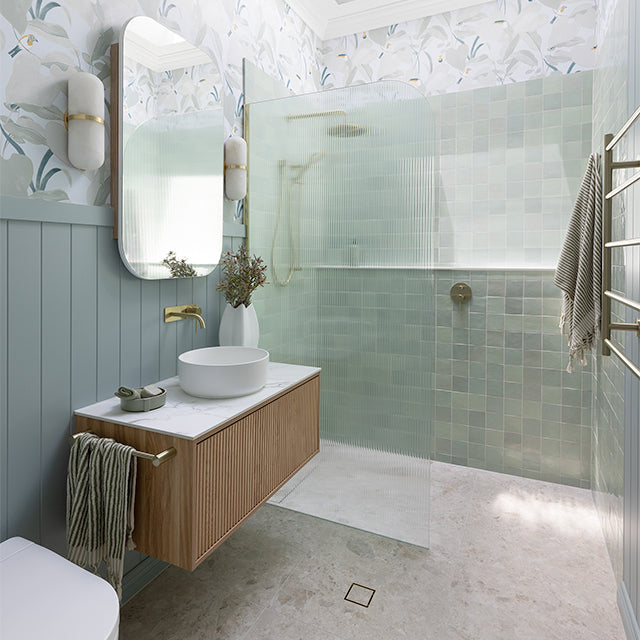Phoenix Vivid Slimline brushed gold wall-mounted shower/bath diverter mixer in a bathroom vanity and shower setting