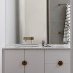 Phoenix Vivid Slimline wall basin mixer in brushed gold over a terrazzo vanity in a modern bathroom