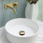Phoenix Vivid Slimline wall basin mixer set in brushed gold over a white basin, with wall-mounted spout and lever control