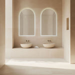 Radiant Ark frameless arched LED mirror in a bathroom, shown above twin basins with soft backlit glow