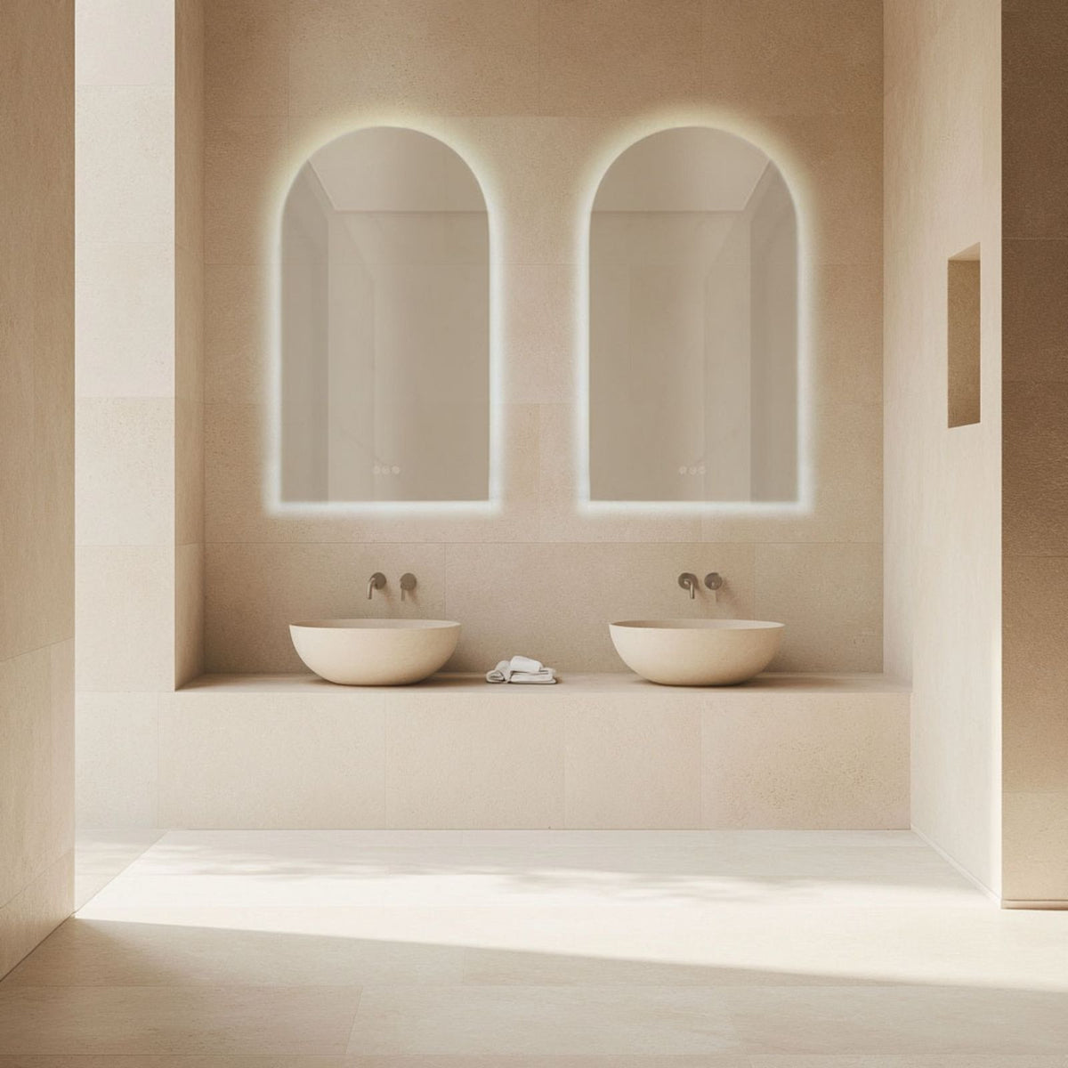 Radiant Ark frameless arched LED mirror in a bathroom, shown above twin basins with soft backlit glow