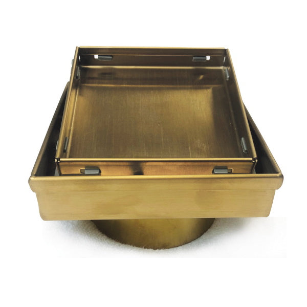 Radiant square tile insert floor waste in brushed gold, front angle on white background