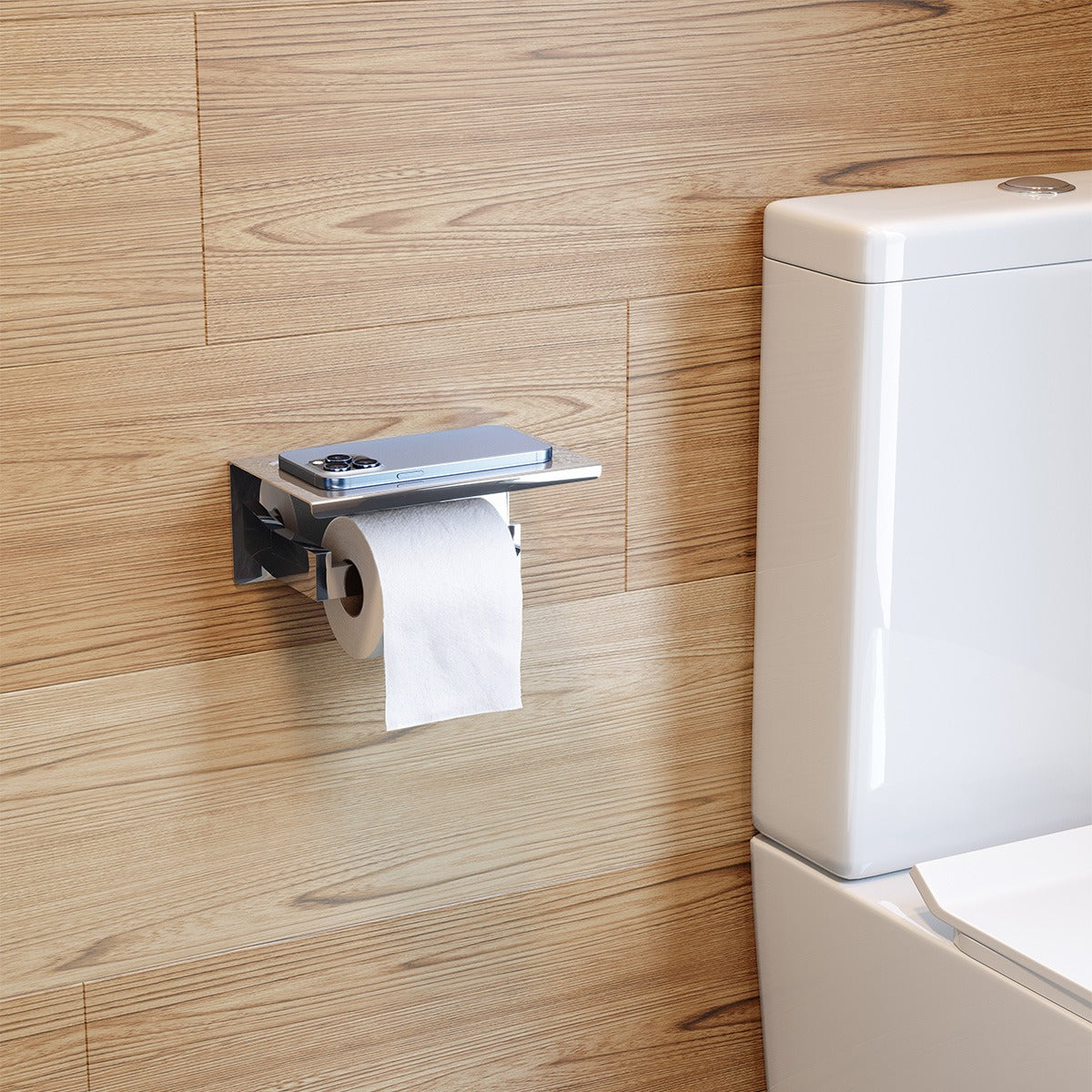 Raymor Edge II chrome toilet roll holder with shelf, wall mounted beside a toilet, holding a roll and a phone on top