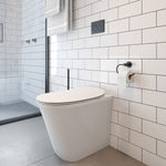 Raymor Edge II white wall-faced rimless toilet with slim seat in a modern tiled bathroom, front angle