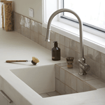 Phoenix Nostalgia pull out sink mixer in brushed nickel, shown over a white farmhouse kitchen sink with tiled splashback