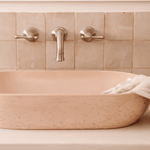 Phoenix Nostalgia brushed nickel wall top assemblies above a pink bath basin in a tiled bathroom