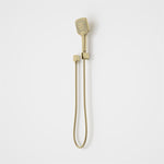 Caroma Luna multifunctional hand shower in brushed brass with hose and wall bracket on a white background