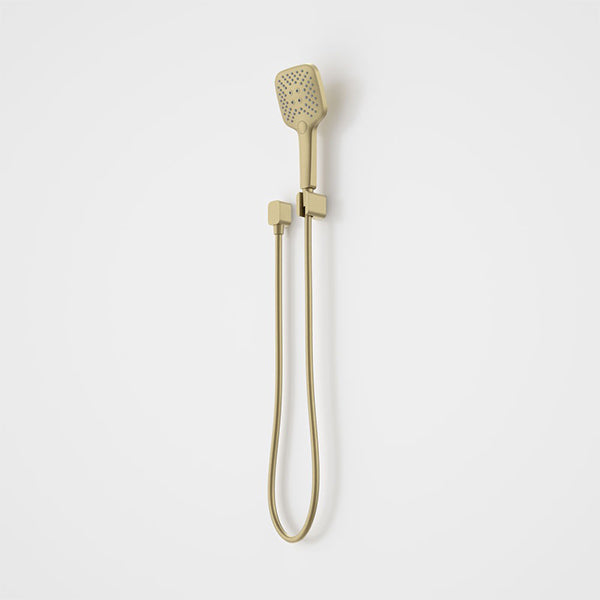 Caroma Luna multifunctional hand shower in brushed brass with hose and wall bracket on a white background
