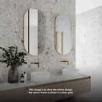 Two Thermogroup pill-shaped framed mirrors in gold above a double vanity, shown in a bathroom setting; black frame variant noted in title
