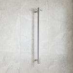 Thermogroup polished stainless steel heated towel rail, straight vertical single bar, wall mounted against light stone tiles