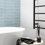 Thermogroup Thermorail black non-heated towel ladder with round bars, wall-mounted beside a bath