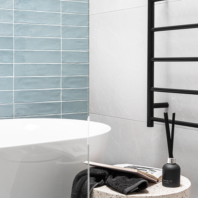 Thermogroup Thermorail black non-heated towel ladder with round bars, wall-mounted beside a bath