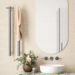 Thermogroup brushed gun metal vertical heated towel rail in a bathroom, with optional top hook and towel on a slim round bar