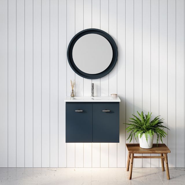 Timberline Florida wall hung vanity in navy blue with white ceramic top, shown in a bathroom setting with round mirror