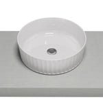 Timberline Allure Flute matte white round above counter basin with fluted outer edge on a vanity top, angled view