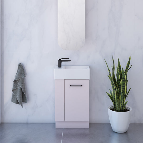 Timberline Frankie small floor standing vanity with white ceramic top, pink cabinet and matte black handle in bathroom setting