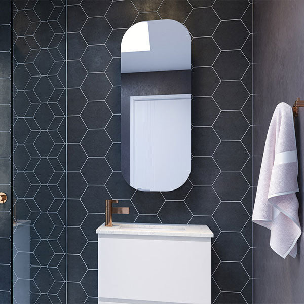 Timberline Jazz Arch Mirror in white satin finish, shown above a bathroom vanity against dark hexagon tiles