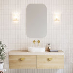 Timberline Kingsley wall hung vanity in light woodgrain with silk surface top and above counter basin, shown in bathroom setting