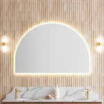 Timberline Melody arch mirror above a double vanity, with white satin edging and warm backlighting in a bathroom display