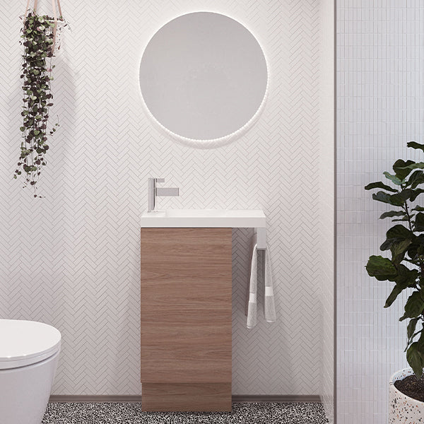 Timberline Oscar floor standing vanity in prime oak with white top, chrome towel rail and round mirror in ensuite setting