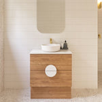 Timberline Oxbow freestanding vanity with woodgrain drawers, white stone top and round basin in bathroom setting