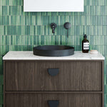 Timberline Radius inset basin in matte black, round above-counter bathroom basin on a vanity with green tiled wall backdrop