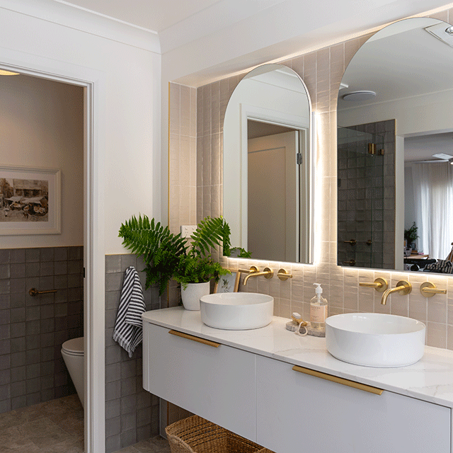 Timberline Church arched shaving cabinet with backlit mirror above a bathroom vanity and basin sinks