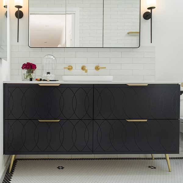 Timberline Sutherland House Deco floor-standing vanity in black, with four drawers, brass handles and gold legs in a bathroom setting