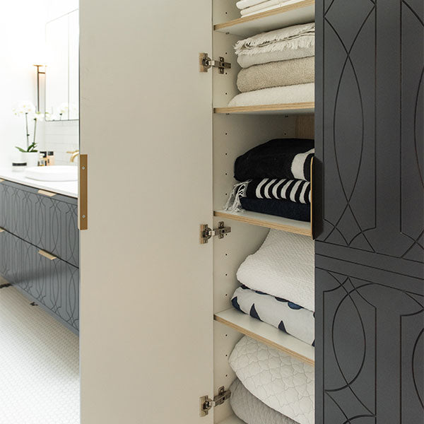 Timberline Sutherland House Deco wall hung storage cabinet, open black door showing white and oak shelves with folded towels