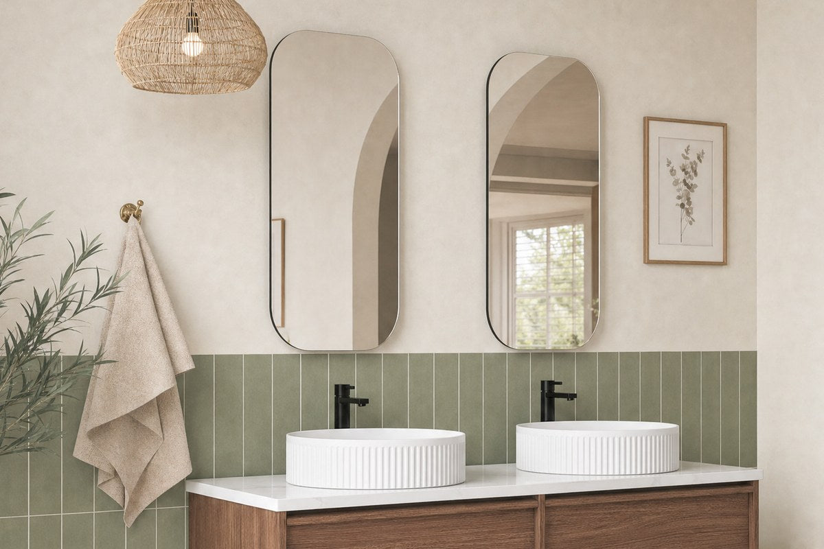 Twin pill mirrors over a walnut double vanity with green tiles