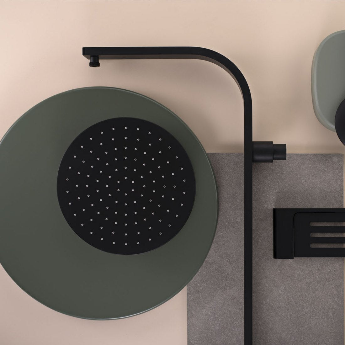 Close-up of a matt green rain shower head with a black shower arm and wall shelf