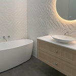 Modern bathroom with Clark chrome round swivel bath outlet beside a freestanding bath and vanity with basin
