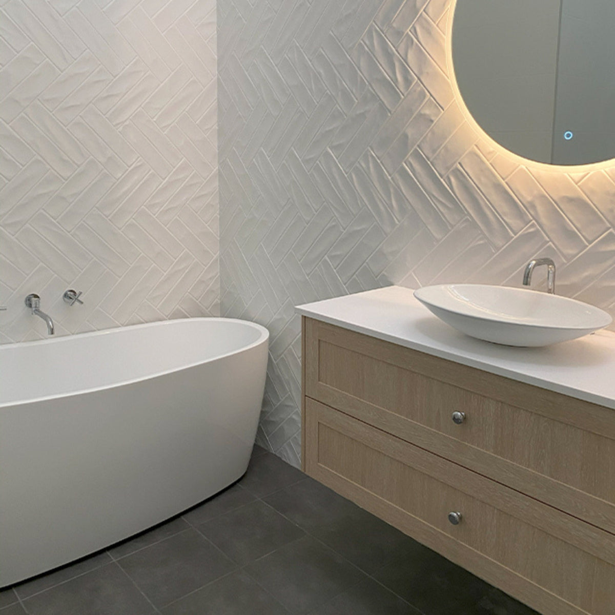 Modern bathroom with Clark chrome round swivel bath outlet beside a freestanding bath and vanity with basin