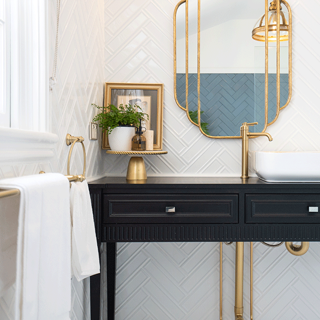 Phoenix Cromford vessel mixer in brushed gold on a black vanity beside an above-counter basin.