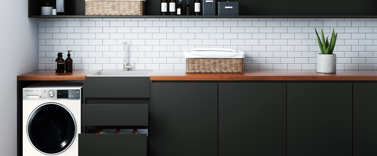 Black themed laundry with wood accents and white appliances with chrome tapware