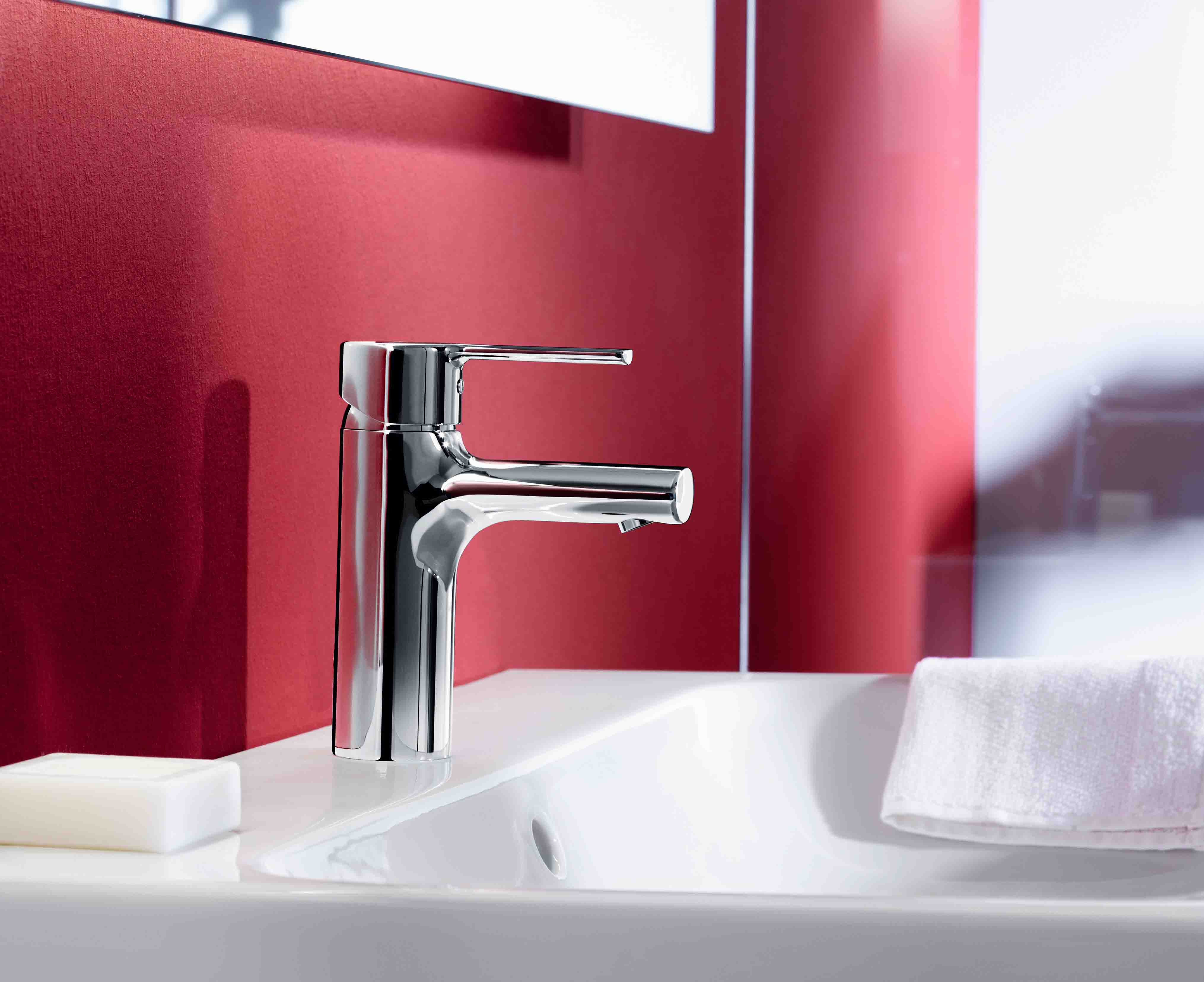 Red feature wall of bathroom showing chrome tap and white basin