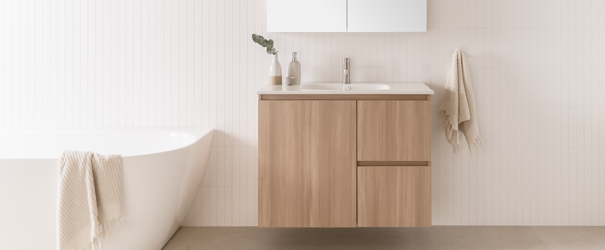 Neutral coloured bathroom with wood vanity, white bath and chrome tapware