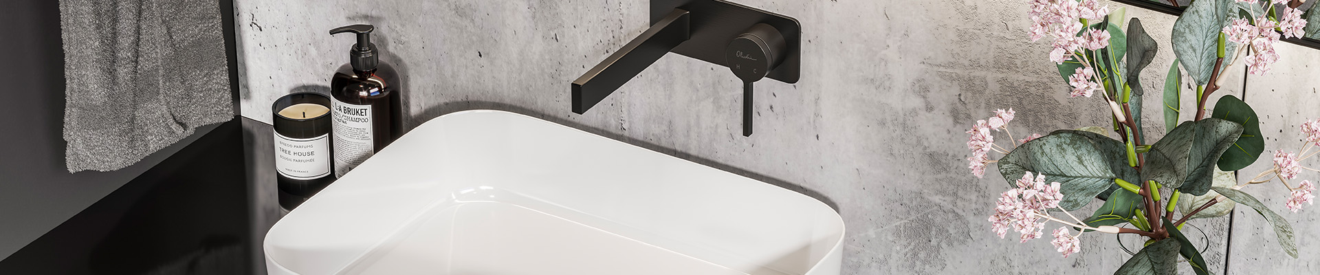 Rectangular white bathroom basin on black counter with black wall mounted basin mixer