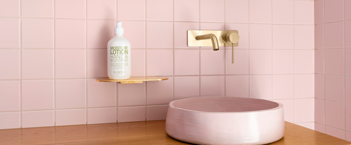 Pink tile bathroom with pink basin and gold tapware