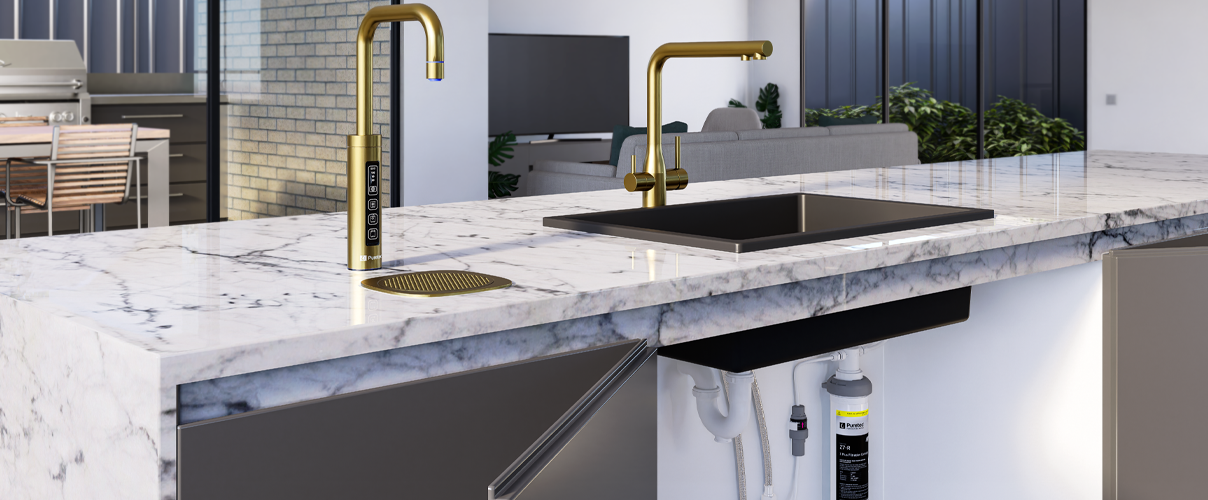 Marble countertop with black sink and gold mixer as well as gold filtered water tap